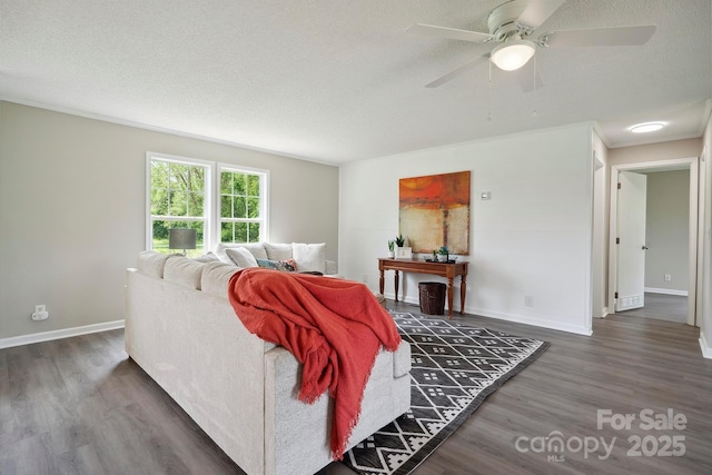 living area featuring a ceiling fan, a textured ceiling, wood finished floors, and baseboards