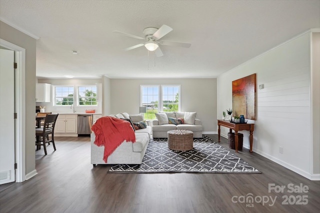 living area featuring crown molding, dark wood-style floors, ceiling fan, and baseboards