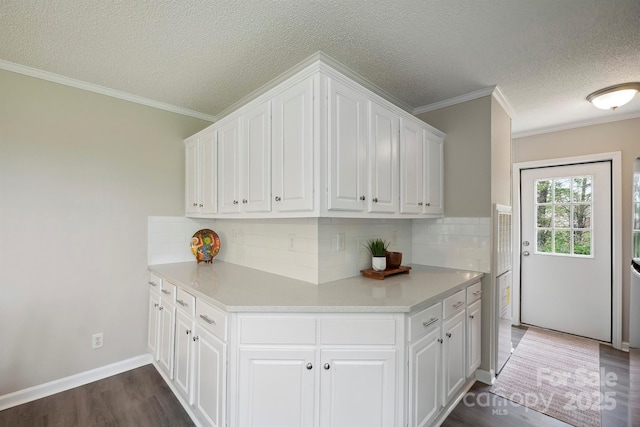 kitchen with a textured ceiling, white cabinets, backsplash, and dark wood-type flooring