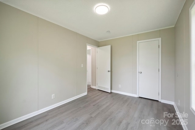 unfurnished bedroom featuring wood finished floors and baseboards