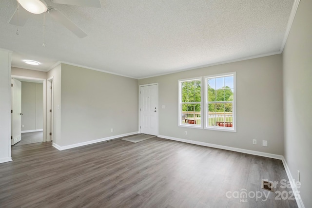 spare room featuring a textured ceiling, ornamental molding, and dark wood finished floors