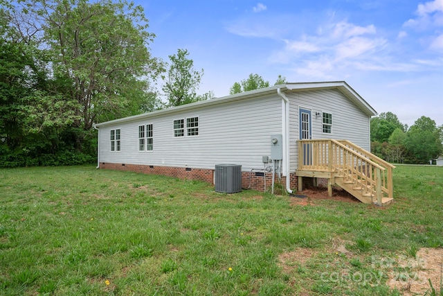 back of house featuring a yard, central air condition unit, and crawl space