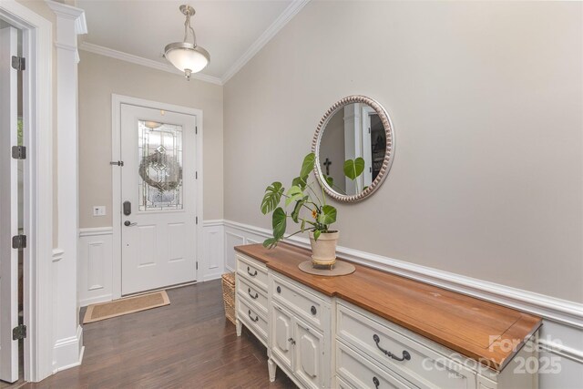 entrance foyer with a wainscoted wall, dark wood-type flooring, and ornamental molding