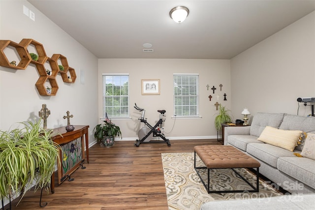 living area featuring baseboards, wood finished floors, and visible vents