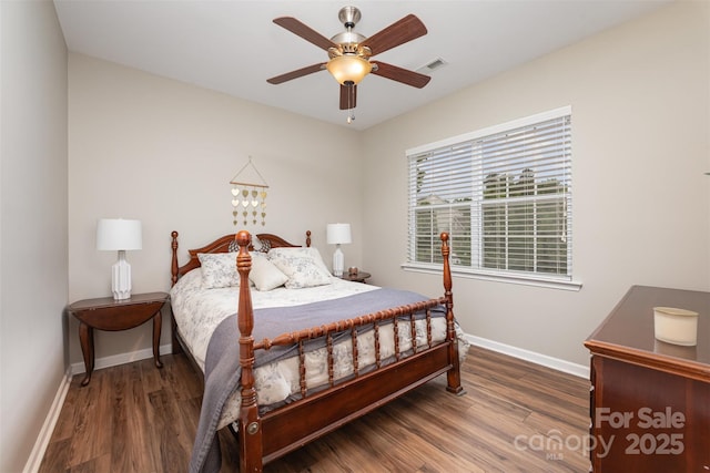 bedroom with wood finished floors, visible vents, a ceiling fan, and baseboards