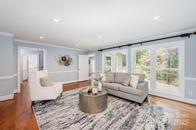 living area with wood finished floors, baseboards, recessed lighting, and ornamental molding