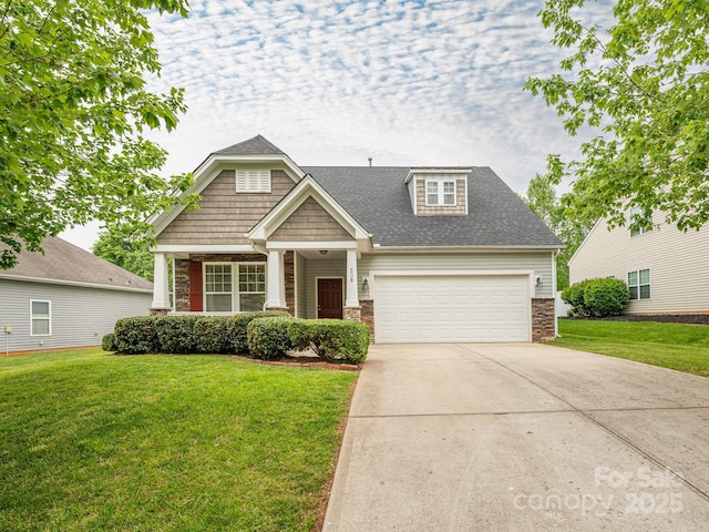craftsman-style house with a garage, a front yard, concrete driveway, and stone siding