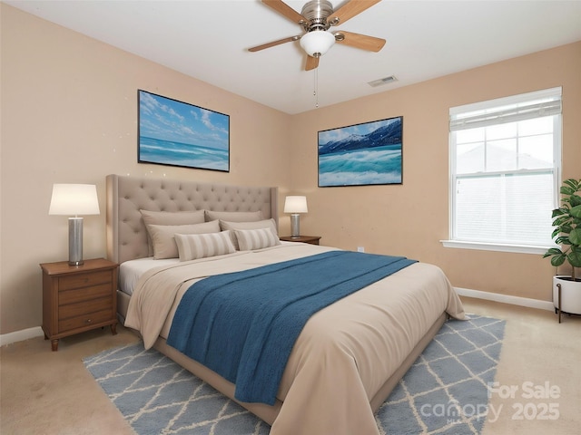 carpeted bedroom with visible vents, a ceiling fan, and baseboards
