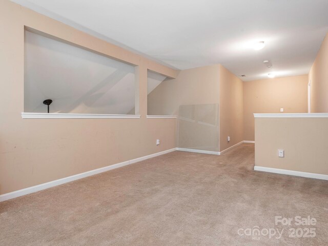 carpeted spare room with baseboards