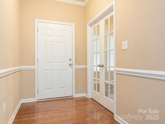 doorway to outside with baseboards, wood finished floors, french doors, and crown molding