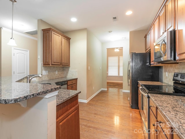 kitchen with a breakfast bar area, tasteful backsplash, appliances with stainless steel finishes, baseboards, and brown cabinetry
