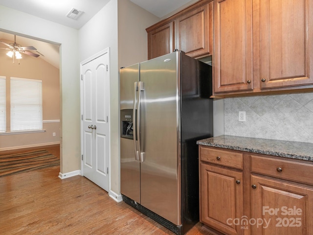 kitchen featuring tasteful backsplash, ceiling fan, light wood finished floors, visible vents, and stainless steel refrigerator with ice dispenser