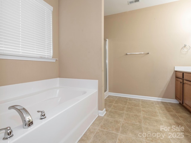 full bathroom featuring a shower stall, vanity, a bath, visible vents, and baseboards