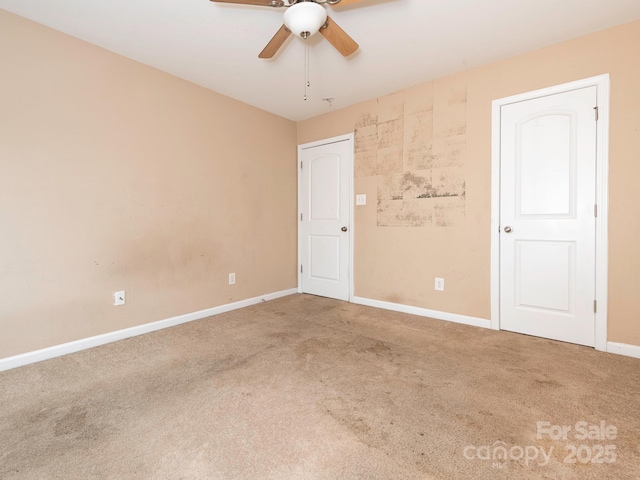 empty room featuring baseboards, ceiling fan, and carpet flooring