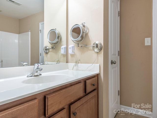 bathroom with tile patterned floors, visible vents, and vanity