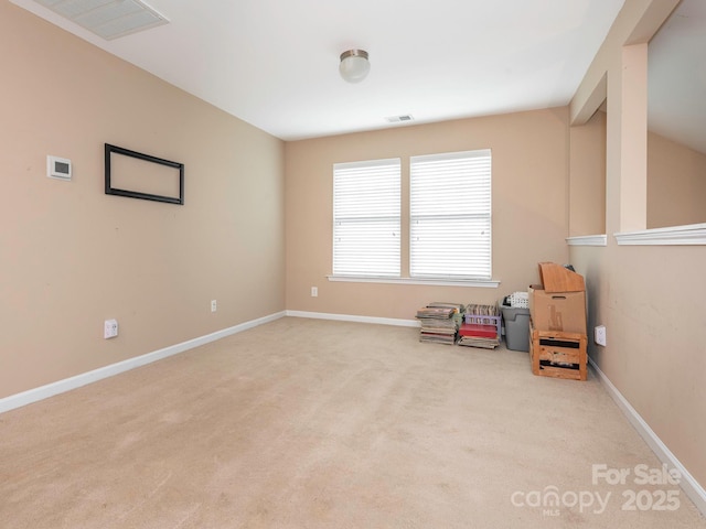 empty room featuring carpet, visible vents, and baseboards