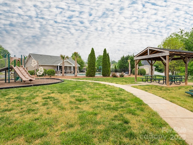 view of community featuring a yard, a gazebo, playground community, and fence