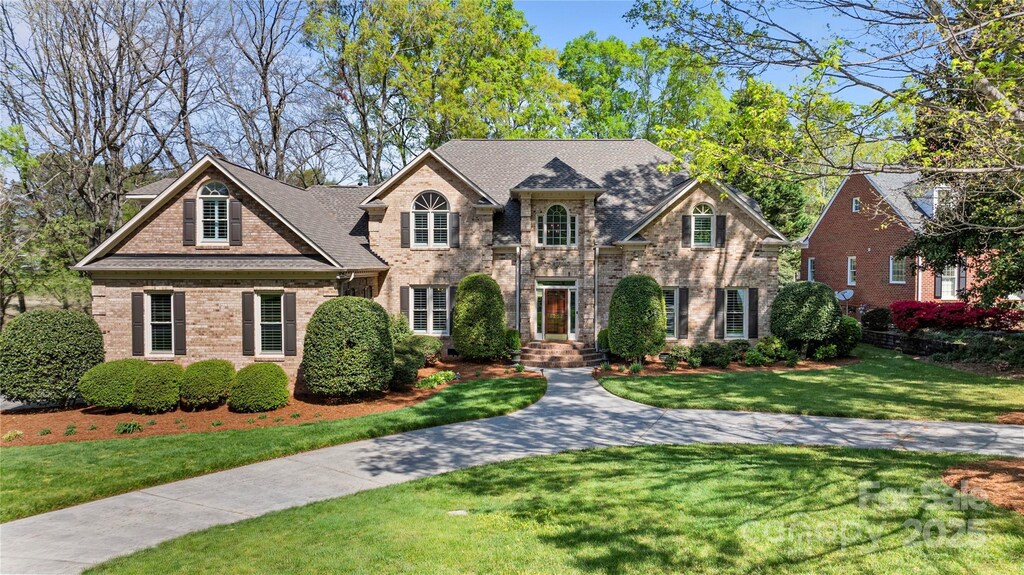 view of front of home with brick siding and a front yard