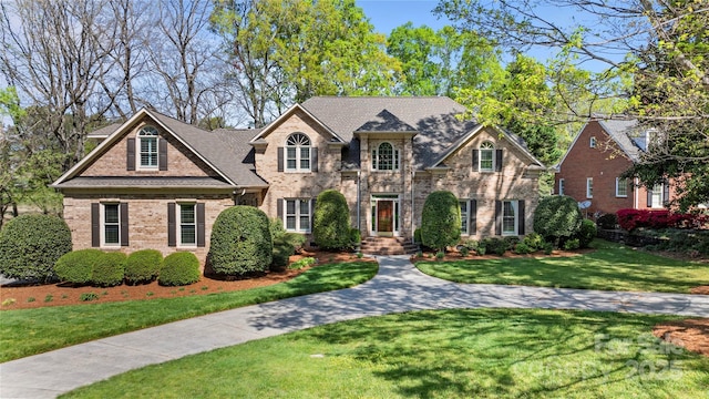 view of front of home with brick siding and a front yard