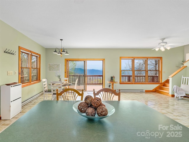 dining area with ceiling fan with notable chandelier, baseboards, stairs, and a baseboard radiator