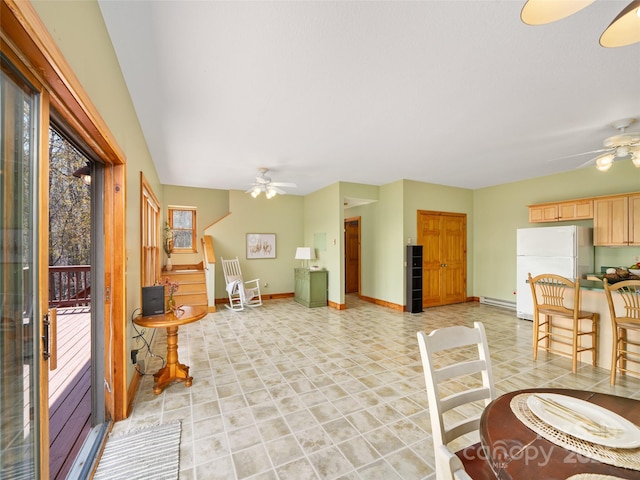 interior space featuring baseboard heating, ceiling fan, baseboards, and stairs