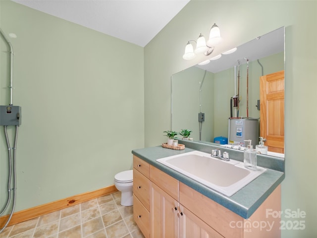 bathroom with water heater, vanity, toilet, and baseboards