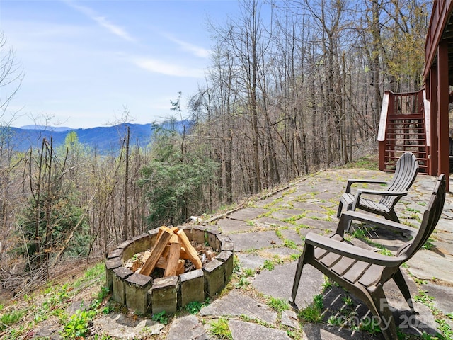 view of patio / terrace featuring a fire pit, stairway, and a mountain view