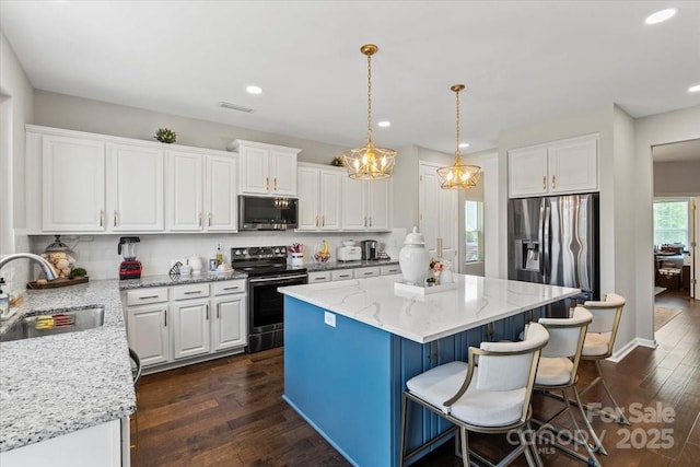 kitchen featuring white cabinets, stainless steel appliances, a sink, and dark wood finished floors