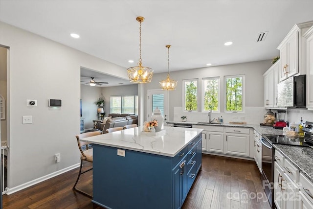kitchen with white cabinets, electric range oven, blue cabinetry, and a sink