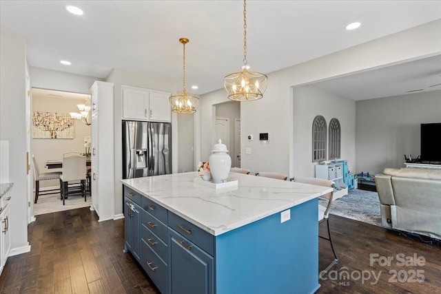 kitchen featuring a chandelier, stainless steel fridge, blue cabinetry, white cabinetry, and dark wood-type flooring