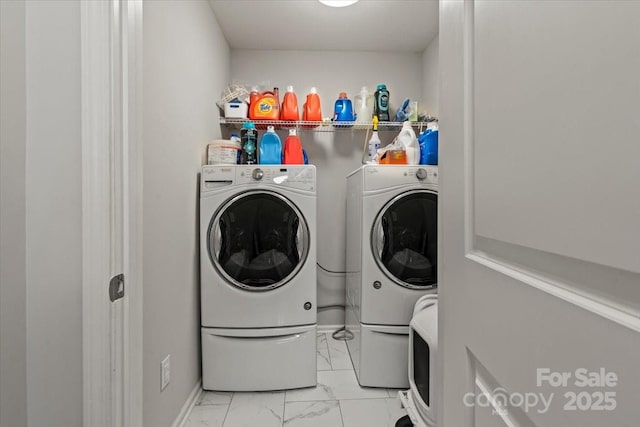 washroom with marble finish floor, washer and dryer, and laundry area