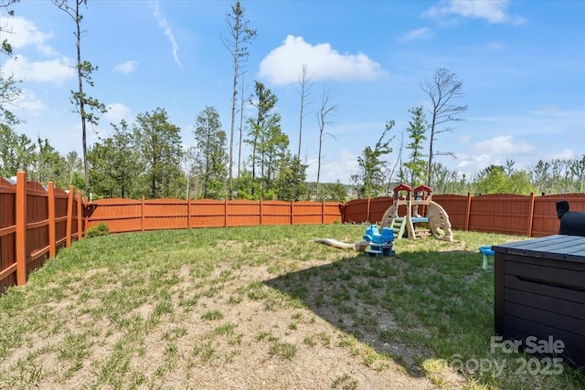 view of yard featuring a fenced backyard and a playground