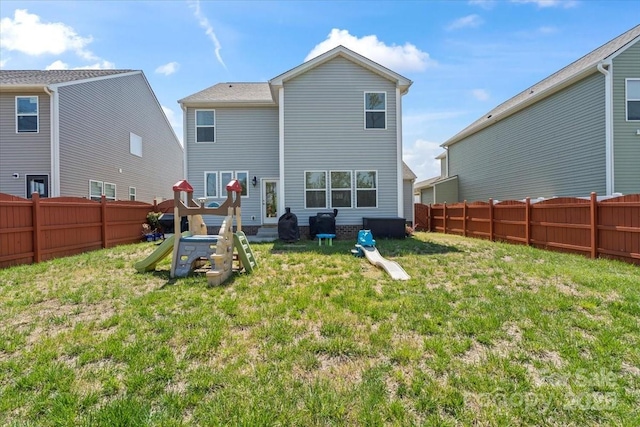 rear view of house featuring a fenced backyard and a yard