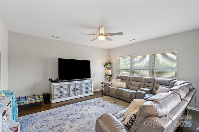 living area featuring baseboards, a ceiling fan, wood finished floors, and visible vents