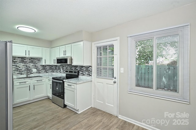 1931 Mereview Ct Unit 46, Charlotte, NC 28210 - kitchen with stainless steel appliances, backsplash, light wood finished floors, white cabinets, and a textured ceiling