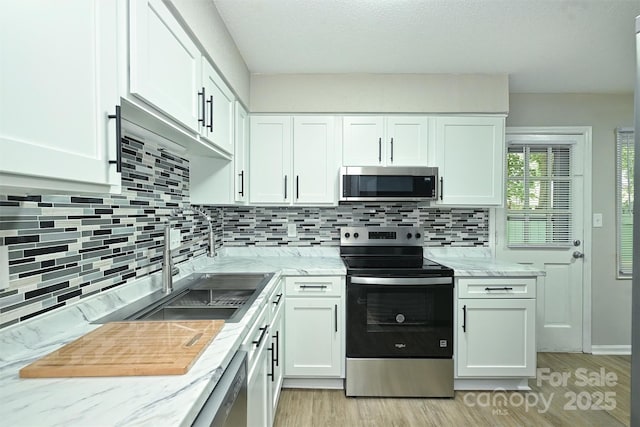 1931 Mereview Ct Unit 46, Charlotte, NC 28210 - kitchen featuring stainless steel appliances, tasteful backsplash, white cabinetry, and light wood-style floors