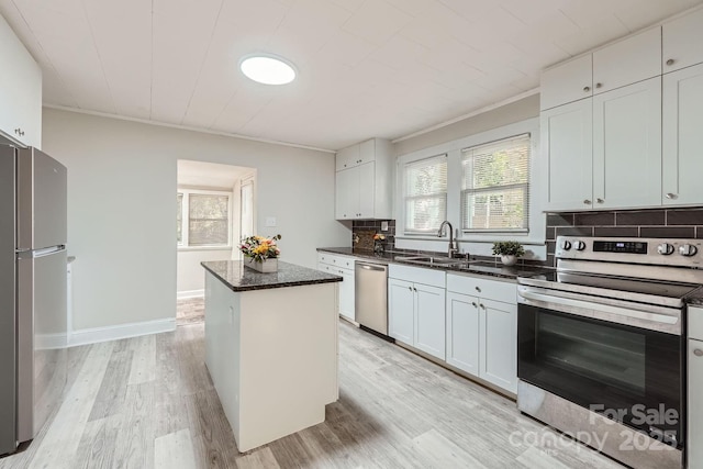 828 Richard Ave, Kannapolis, NC 28081 - kitchen with a center island, tasteful backsplash, a sink, stainless steel appliances, and light wood finished floors