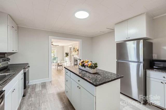 828 Richard Ave, Kannapolis, NC 28081 - kitchen with light wood-type flooring, a kitchen island, dark stone counters, and stainless steel appliances