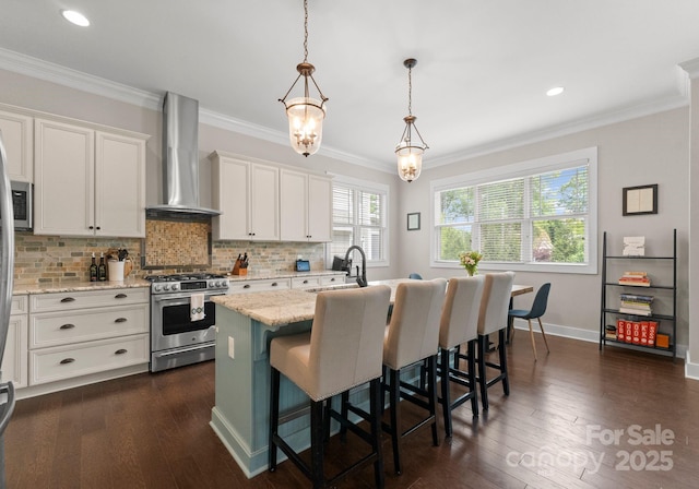 kitchen with white cabinetry, a sink, wall chimney range hood, and gas stove
