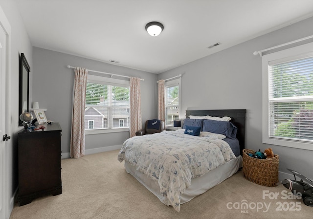 bedroom with visible vents, light carpet, and baseboards