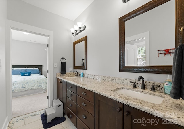 ensuite bathroom with double vanity, a sink, tile patterned floors, and ensuite bathroom
