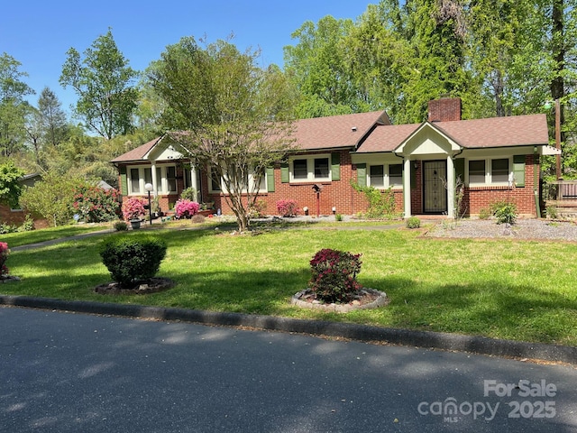 ranch-style home featuring brick siding, a front lawn, and a chimney