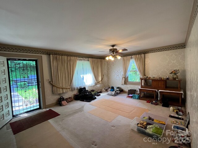 interior space with a ceiling fan, carpet flooring, and wallpapered walls