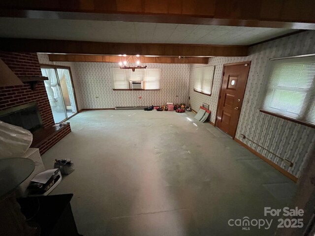 unfurnished living room with a fireplace, wallpapered walls, and cooling unit