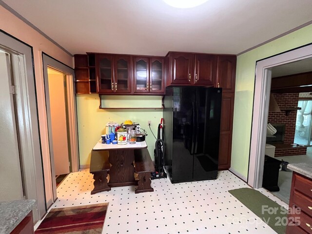 kitchen with glass insert cabinets and black fridge with ice dispenser