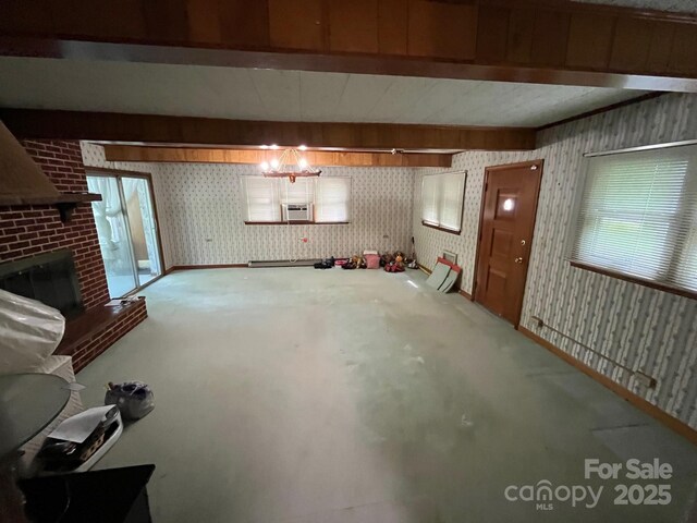 below grade area featuring plenty of natural light, a wall mounted air conditioner, a brick fireplace, and wallpapered walls
