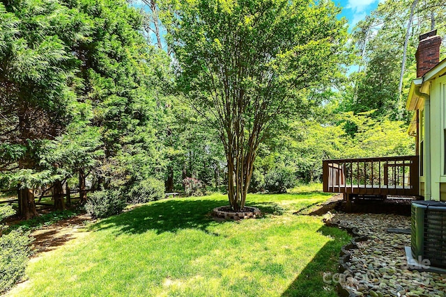 view of yard featuring cooling unit and a deck