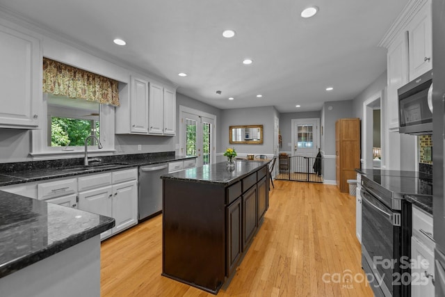 kitchen with stainless steel appliances, a sink, white cabinetry, and recessed lighting