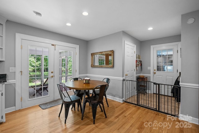 dining space with light wood finished floors, recessed lighting, and french doors