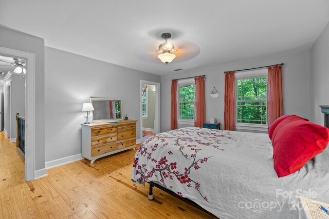 bedroom with wood finished floors, baseboards, and ceiling fan